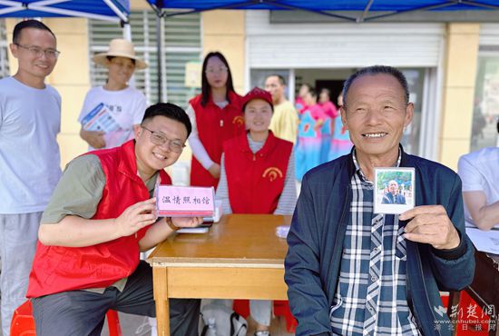 “溫情照相館”攤位上，前來照相的老人與志愿者開心地合影留念_副本.jpg